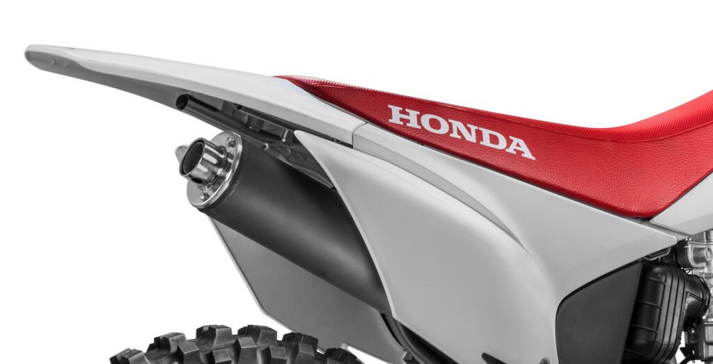 fotografia da moto honda crf 230 mostrando o sistema de escapamento da crf 230 pelo lado direito da moto, focando em mostrar a ponteira original da moto e o paralama traseiro