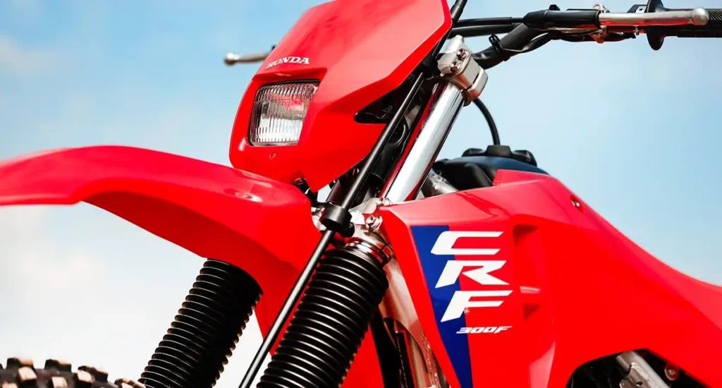 fotografia mostrando a frente da moto honda crf 300f, a nova mesa de alumínio, suspensão dianteira telescópica de 41 mm com curso de 240 mm